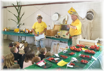 Beth and Rick teaching children about honeybees. Beth and Rick teaching children about honeybees.