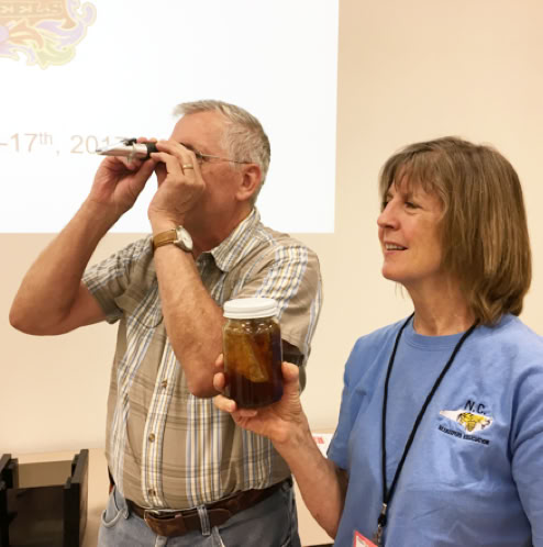 Zach learning how to use a refractometer to check honey moisture.
